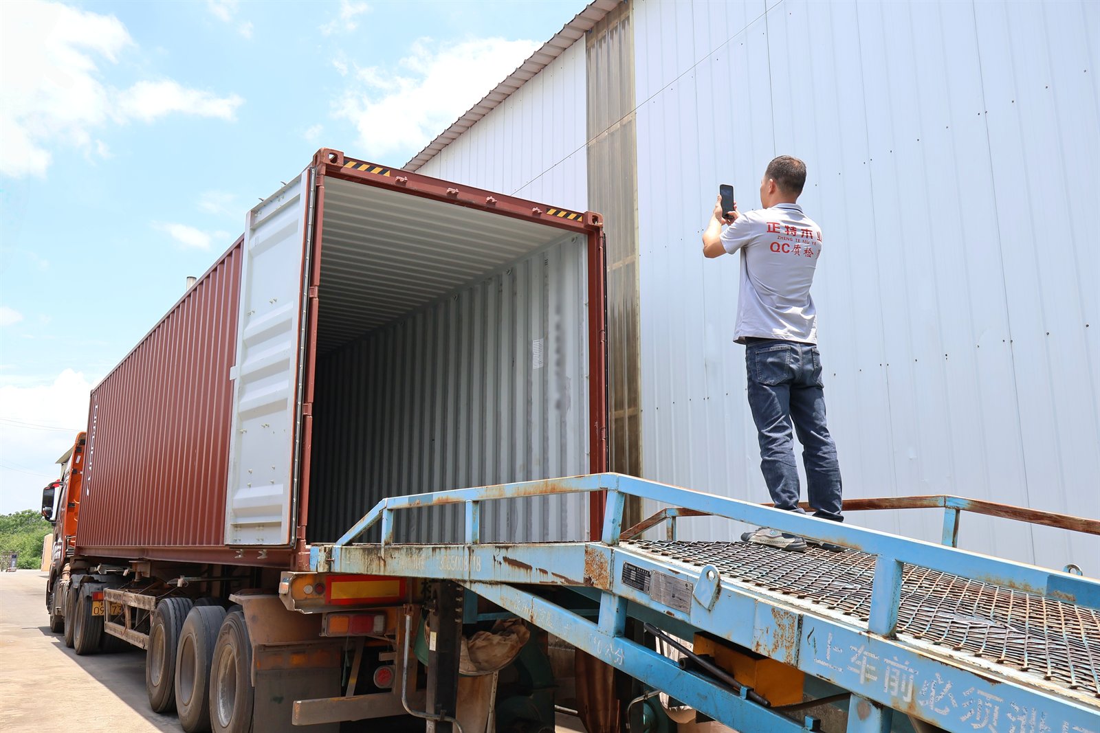 QC staff checking empty container condition before plywood loading